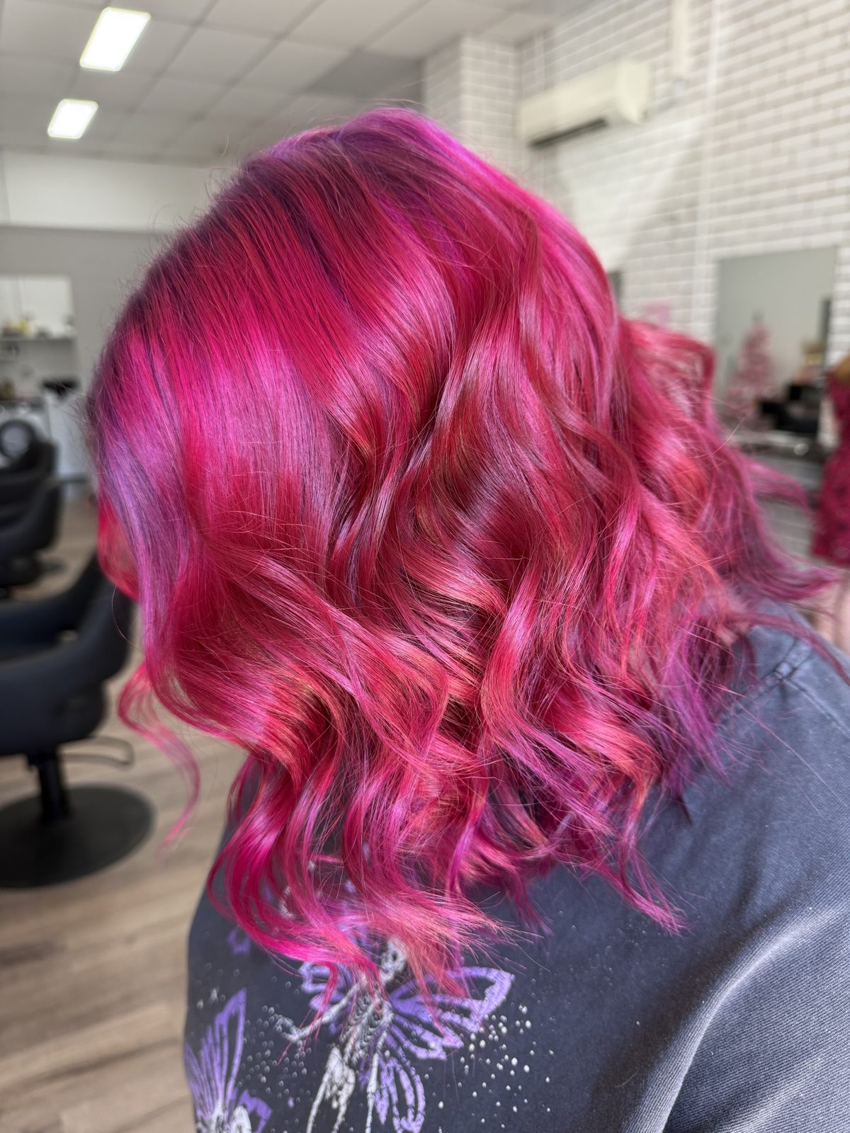 Vivid magenta hair colour with loose waves, finished at Studio L